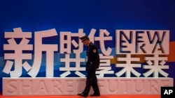 一名警卫在上海中国国际进口博览会的口号前走过。（2018年11月5日）