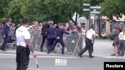 Potongan gambar dari sebuah video yang menunjukkan anggota pasukan pengamanan Perdana Menteri Slovakia Robert Fico menahan seorang pria dalam insiden penembakan terhadap Fico di Handlova, Slovakia, pada 15 Mei 2024. (Foto: RTV PRIEVIDZA/Handout via Reuters)