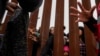 Un contrabandista mexicano guía a una familia haitiana a través de la presa Morelos sobre el río Colorado desde Los Algodones, México, el viernes 4 de febrero de 2022, hasta Yuma, Arizona, en el otro lado. 