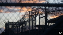 FILE - Dawn breaks at the now closed Camp X-Ray, used as the first detention facility for suspected militants captured after the Sept. 11 attacks, at the Guantanamo Bay Naval Base in Cuba, dawn arrives at the now closed Camp X-Ray.