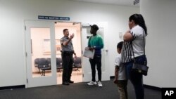 Un agente recibe a personas en un tribunal, el 10 de enero de 2024, en una corte de inmigración de Miami. 
