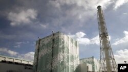 Tokyo Electric Power Co. (TEPCO)'s tsunami-crippled Fukushima Daiichi nuclear power plant No.6 (L) and No.5 reactor buildings are seen from a bus window in Fukushima prefecture, February 20, 2012