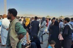Los afganos se agolpan en la pista del aeropuerto de Kabul el 16 de agosto de 2021 para huir del país, ya que los talibanes controlaban Afganistán después de que el presidente Ashraf Ghani huyó del país.