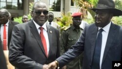 South Sudan's First Vice President Riek Machar, left, and President Salva Kiir, right, shake hands following the first meeting of a new transitional coalition government, in the capital Juba, April 29, 2016. 