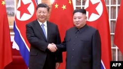 김정은 북한 국무위원장과 시진핑 중국 국가주석이 평양에서 만나 악수하는 모습을 중국 관영 신화통신이 보도했다. (자료사진)