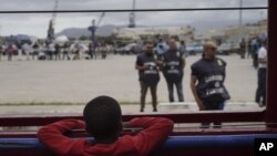 Seorang anak laki-laki mengamati polisi dari atas kapal Ocean Viking di Laut Mediterania, Selasa, 24 September 2019. Dia adalah salah satu di antara 182 orang migran yang diselamatkan di Laut Mediterania, utara Libya. (Foto AP / Renata Brito)