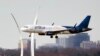 A JetBlue passenger plane passes the Air Force Memorial as it prepares to land at Reagan Washington National Airport in Arlington, Virginia, across the Potomac River from Washington, Jan. 19, 2022. 
