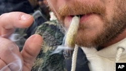 ARCHIVO - Un hombre fuma marihuana en Lower Manhattan afuera del primer dispensario legal de marihuana recreativa en Nueva York el jueves 29 de diciembre de 2022. 