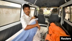 A man holds his sick child who consumed spurious meals at a school on Tuesday in the eastern Indian city of Patna, India July 17, 2013.