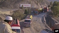 A driver sits overlooking trucks parked along the road, including those carrying supplies to NATO forces in Afghanistan, near Pakistan's Torkham border, after it was shut down to traffic November 26, 2011.