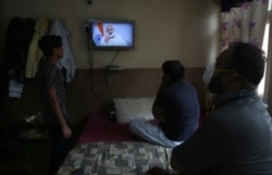 People in Hyderabad, India watch Prime Minister Narendra Modi address the nation in a televised speech about COVID-19 situation, Tuesday, April 14, 2020.