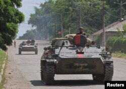 Los miembros del servicio de las tropas prorrusas viajan en un vehículo de combate de infantería durante la guerra en Ucrania, en la ciudad de Lysychansk en la región de Lugansk, Ucrania, 4 de julio de 2022. REUTERS/Alexander Ermochenko