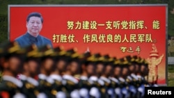 资料照：解放军士兵列队在中国领导人习近平画像以及他提出的“能打胜仗，作风优良”的口号前走过。（2015年8月22日）