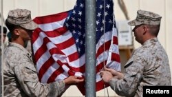 FILE - U.S. officials say they'll discard plans to draw down troop strength to 5,500 by year's end in Afghanistan. Here, U.S. Marines lower their flag during a handover ceremony, as the last U.S. Marines unit and British combat troops end their Afghan operations in Helmand, Oct. 26, 2014. 