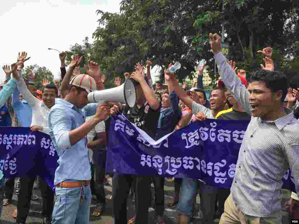 ក្រុមអ្នកតវ៉ាដែលភាគច្រើនជាយុវជន ស្រែកពាក្យស្លោក ខណៈពេលដែលពួកគេបានប្រមូលផ្តុំគ្នានៅមុខរដ្ឋសភាជាតិ និងស្នើឲ្យមានការដកតំណែងលោកកឹម សុខា អនុប្រធានទី១នៃរដ្ឋសភាជាតិ ដោយលើកហេតុផលថាលោកប្រើនយោបាយភូតភរបោកប្រាស់និងលាបពណ៌ កាលពីព្រឹកថ្ងៃច័ន្ទ ទី២៦ ខែតុលា ឆ្នាំ២០១៥។ (នៅ វណ្ណារិន/VOA)
