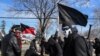 Activistas de antifa enmascarados y vestidos de negro durante una protesta en Michigan el 4 de marzo de 2018.