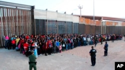 FILE - The U.S. Customs and Border Protection shows some of 1,036 migrants who crossed the U.S.-Mexico border in El Paso, Texas, May 29, 2019. 
