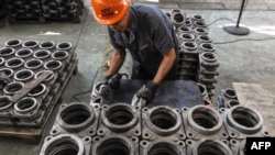 An employee works on transmission parts at a factory in Lianyungang in China's eastern Jiangsu province, Sept. 14, 2018. The Chinese economy revealed fresh signs of softness, with data showing the pace of investment slowing to record lows while retail spending and industrial production stabilized.