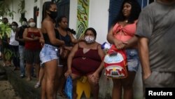 Members of the community Quilombo Quilomba, descendants of African slaves, wait to receive shots of Sinovac's CoronaVac vaccine, in Mage, Rio de Janeiro state, Brazil, April 7, 2021.