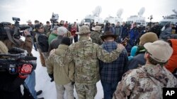 FILE - Members of the group occupying the Malheur National Wildlife Refuge headquarters hug after Ammon Bundy, center, left, one of the sons of Nevada rancher Cliven Bundy, spoke with reporters during a news conference Monday, Jan. 4, 2016, near Burns, Oregon.
