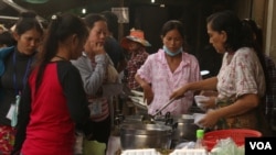 កម្មការិនីរោងចក្រទិញម្ហូបចម្អិនស្រាប់នៅទិដ្ឋភាពនៃបន្ទប់ស្នាក់នៅជួលរបស់កម្មកររោងចក្រនៅតំបន់ផ្លូវវេងស្រេង កាលពីថ្ងៃទី២៤ ខែកក្កដា ឆ្នាំ២០១៥។ (ស៊ូ ពិសែន/VOA)