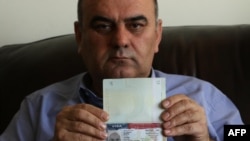 Fuad Sharef Suleman shows his US immigrant visa in Arbil, the capital of the Kurdish autonomous region in northern Iraq, on January 30, 2017 after returning to Iraq from Egypt, where him and his family were prevented from boarding a plane to the U.S. foll