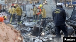 Personal de rescate trabaja en el lugar de un edificio quemado durante el incendio de Eaton en Altadena, California, EEUU, el 13 de enero de 2025.