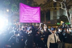 Agentes de policía levantan una bandera de advertencia contra los simpatizantes frente a un tribunal en Hong Kong, el jueves 4 de marzo de 2021.