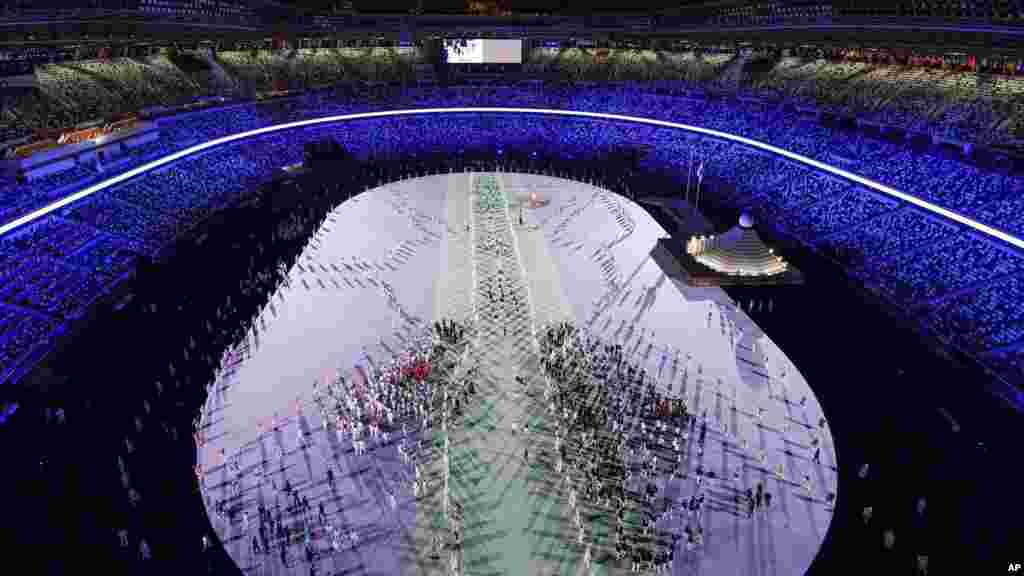 Los atletas caminan dentro del Estadio Olímpico de Tokio el 23 de julio de 2021, durante la ceremonia de apertura de los Juegos Olímpicos.