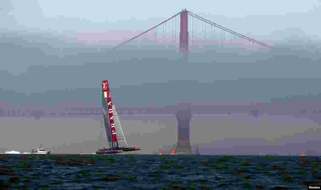 'Luna Rossa Challenge' berlayar dekat Jembatan Golden Gate mendahului Tim Emirates Selandia Baru dalam Kejuaraan Perahu Layar memperebutkan piala Louis Vuitton di San Francisco, California, 18 Agustus 2013.