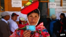 Una mujer muestra su documento de identidad en una mesa electoral en Ollantaytambo, en la provincia de Urubamba, región de Cusco, mientras el país vota sobre las reformas constitucionales el 9 de diciembre de 2018.
