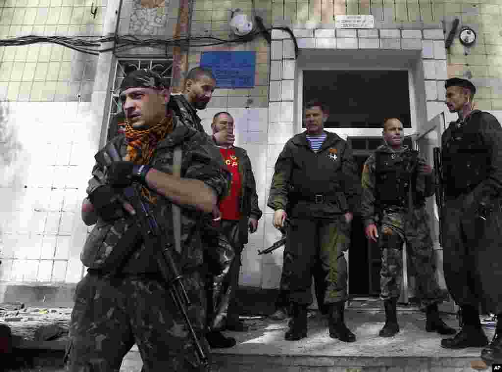 Donetskdagi isyonchilar rahbari Aleksandr Zaxarchenko (markazda) shikastlangan maktab binosini ko'zdan kechirmoqda, 1-oktabr, 2014-yil.