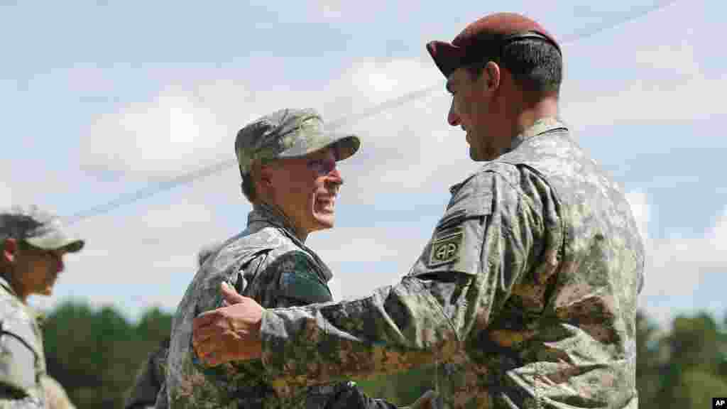 La première lieutenant Shaye Haver, à gauche, est félicitée par un soldat non identifié avant une cérémonie de remise des diplômes de l'école des Rangers de l’armée américaine vendredi 21 août 2015, à Fort Benning, en Géorgie. 