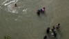 Migrantes lavan ropa en el río Grande cerca de un improvisado campamento ocupado por solicitantes de asilo en el puente internacional Gateway en Matamoros, Tamalipas, México, el 28 de octubre de 2019.