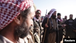 FILE - Yazidi fighters gather on the summit of Mount Sinjar as they head to battle Islamic State militants, in Iraq, Dec. 21, 2014. IS swept into Sinjar town and surrounding villages in early August; many residents were from the Yazidi religious community.