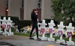 FILE - A woman reacts at a makeshift memorial outside the Tree of Life synagogue following Saturday's shooting at the synagogue in Pittsburgh, Oct. 29, 2018.