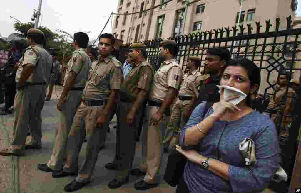 Delhi police secure a gate after protesters broke through a police barrier and entered the court complex demanding the death penalty for the four men convicted in the fatal gang rape of a young woman, New Delhi, Sept. 11, 2013.