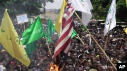 Warga yang marah atas video anti Islam membakar bendera AS di kota Kaduna, Nigeria dalam demonstrasi hari Senin (24/9).
