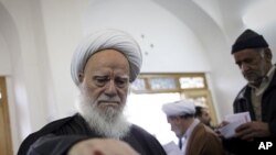 An Iranian clergyman casts his ballot at a polling station at Massoumeh shrine in the holy city of Qom, 130 kms south of Tehran, during parliamentary elections on March 2, 2012.