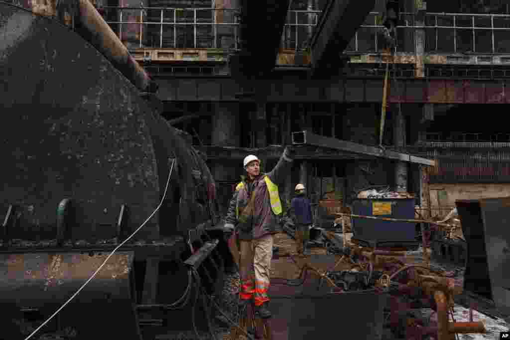 Un miembro del equipo de reparaciones baja una barra de metal al suelo con una grúa, el 28 de noviembre de 2024. 