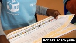 Un agent de la Commission électorale indépendante plie un bulletin de vote dans un bureau de vote à Langa, près du Cap, le 1er novembre 2021, lors des élections locales en Afrique du Sud. 