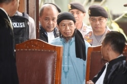 FILE - Islamic cleric Aman Abdurrahman arrives at court ahead of his verdict in Jakarta, Indonesia, June 22, 2018, in this photo by Antara Foto.