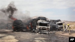Pemadam kebakaran Afghanistan berusaha memadamkan api pasca ledakan yang menghancurkan 22 truk NATO di Samangan, utara Kabul (18/7). 