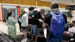 FILE - Arriving passengers are screened by health workers at the airport in Sydney, Australia, Feb. 12, 2021.