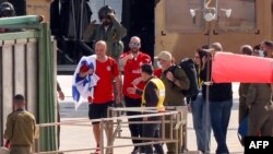 Новоослободениот израелско-аргентински заложник Јаир Хорн (во средина), опкружен со роднини и безбедносни сили, мавта по слегувањето од воен хеликоптер на хелиодромот на Медицинскиот центар во Тел Авив Сураски (Ичилов), на 15 февруари 2025 година.
