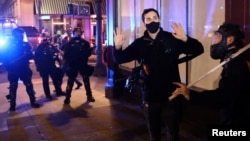 Un manifestante alza las manos frente a la policía durante protestas en Portland, Oregón, el 4 de noviembre de 2020.