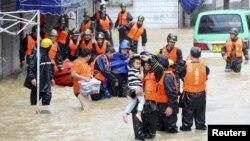 Rescuers help local residents to get to a safe area during heavy rainfall caused by Typhoon Chan-hom, in Shaoxing, Zhejiang province, China, July 11, 2015.