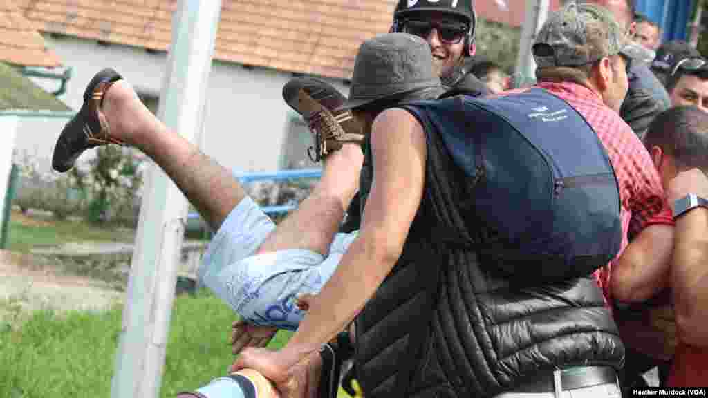 Migrants said a young man's apparent suicide attempt was likely a show to gain sympathy from authorities and journalists, but they added even if the suicide attempt is fake, the desperation he feels is very real, at Harmica, Croatia, Sept. 20, 2015.