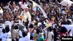 Crowds cheer as Pope Francis arrives at Kololo airstrip in Kampala, Uganda, Nov. 28, 2015.