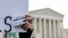 FILE - An abortion- rights activist holds a box of mifepristone pills as demonstrators from both anti-abortion and abortion-rights groups rally outside the Supreme Court in Washington, March 26, 2024. 